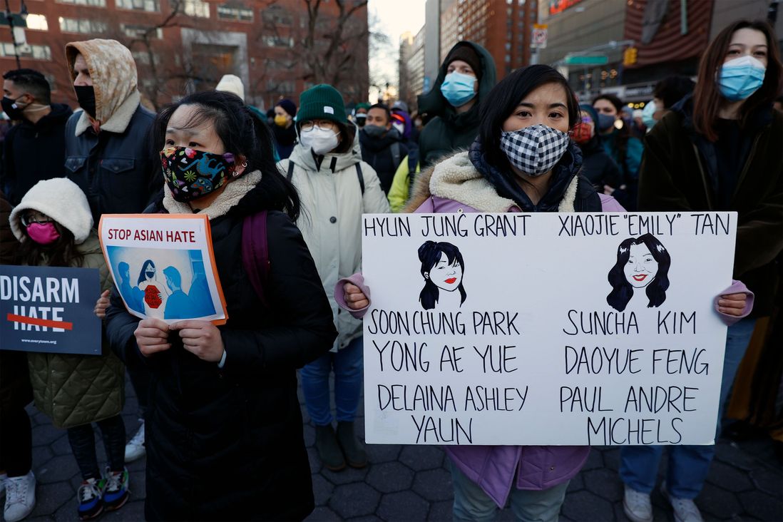 People hold signs in Union Square, including one with the names of all eight victims